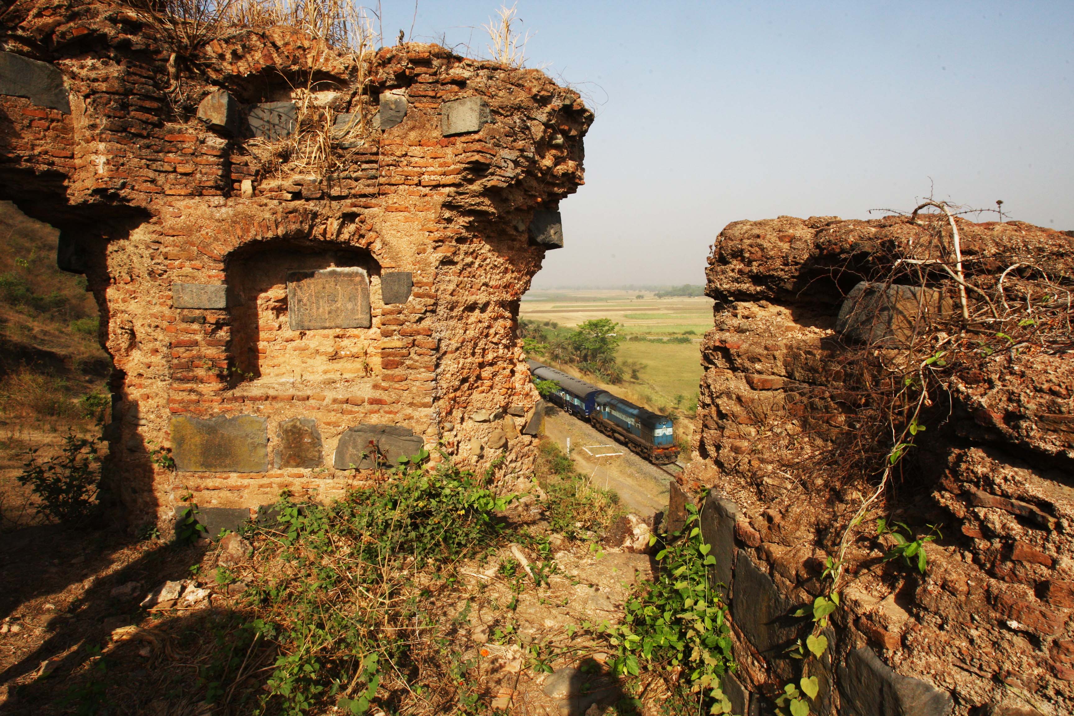A train passes beside Teliagarh Fort